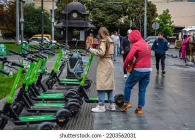 Lviv. Ukraine. July, 2021.Trendy Fashinable Teenager Girls Riding Public Rental Electric Scooters In Urban City Environment. New Eco-friendly Modern Public City Transport