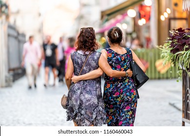 Lviv, Ukraine - July 30, 2018: Two Slavic Eastern European Ukrainian Women Walking Back With Arms Around Each Other Hugging Holding In Historic Ukrainian Polish City In Old Town