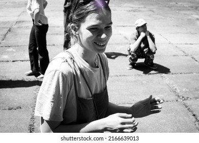 Lviv, Ukraine - June 9, 2022: Happy Smiling Young Woman Hanging Out With Friends Together In The City Street Outdoors. Gritty Street Style Photography