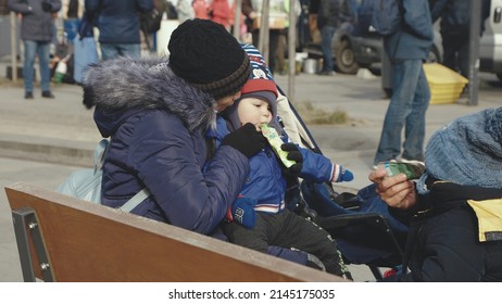 Lviv, Ukraine - March 15, 2022: War in Europe caused by Russia's attack on Ukraine. Ukrainian refugees mother and daughter at the railway station. Woman calming her child