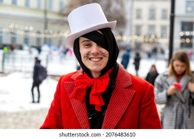 Lviv, Ukraine - March 8, 2021: A Man In A Red Suit In A White Top Hat And With A Painted Mustache Smiles.