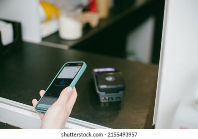 Lviv, Ukraine - MAY 11, 2022:Close-up View Of Girl Using Apple Pay On A Iphone Paying For Purchases