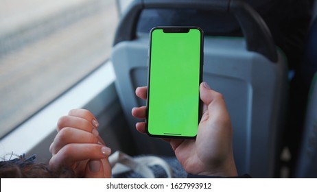 Lviv, Ukraine - May 19, 2018: Hands use touch holding a mobile telephone with a vertical green screen in tram chroma key smartphone technology cell phone street touch message display hand