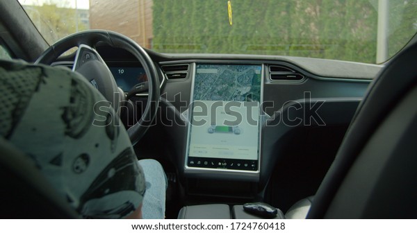 Lviv, Ukraine - May 3, 2020: Modern car driving\
on autopilot. Autopilot car, intelligent vehicle, driveless\
automobile concept.