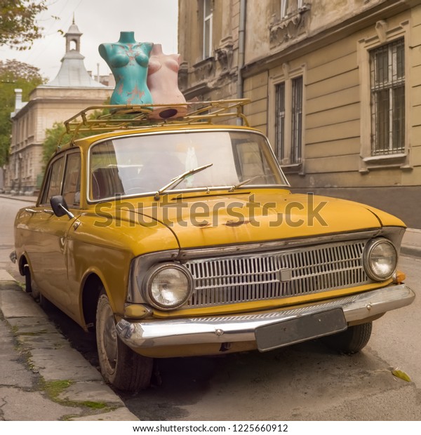 Lviv, Ukraine - Oct. 3, 2018: Classical car. Retro\
car. Retro style. Vintage car. Old car background. Mannequins on\
top of a vehicle. Mannequins on the street. Soviet Union vechicle.\
Square