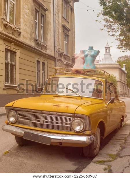 Lviv,\
Ukraine - Oct. 3, 2018: Vintage car. Old car background. Mannequins\
on top of a vehicle. Mannequins on the street. Soviet Union\
vechicle. Classical car. Retro car. Retro\
style.