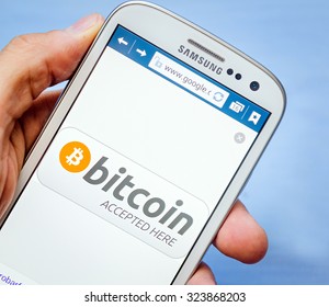 LVIV, UKRAINE - Sept 30, 2015: White Samsung Smart Phone With  Bitcoin Accept Image On Screen,  In Hand