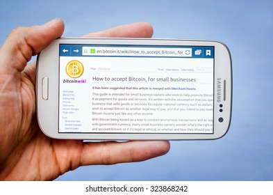 LVIV, UKRAINE - Sept 30, 2015: White Samsung Smart Phone With Wikipedia Page  About Bitcoin For Business ,  In Hand