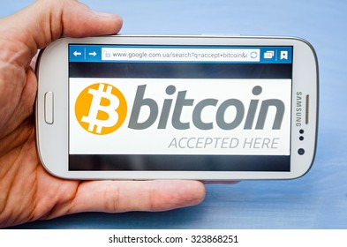 LVIV, UKRAINE - Sept 30, 2015: White Samsung Smart Phone With  Bitcoin Accept Image On Screen,  In Hand