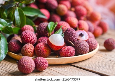 Lychee frui with green leaf on wooden plate background , fresh ripe lychee peeled from lychee tree at tropical fruit Thailand in summer
