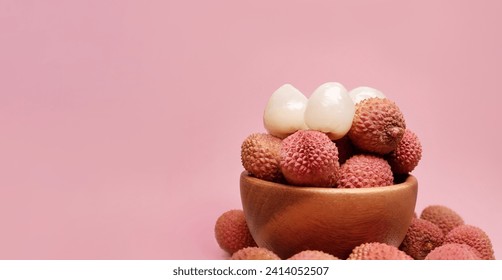 Lychee fruits in a wooden bowl on a pink background. tropical fruit lychee, selective focus.   - Powered by Shutterstock