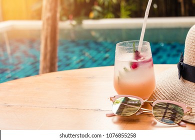 Lychee Soda Cocktails Sunglasses And Straw Hat On Table With Blurred Poolside Background. Summer Drinks Concept.