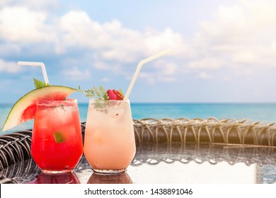 Lychee And Watermelon Soda Cocktails On Table With Blurred Poolside And Beach Background. Summer Drinks Concept.
