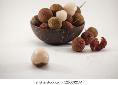 Lychee in a wooden bowl on white background. Delicious tropical fruit. - Shutterstock ID 1260892144