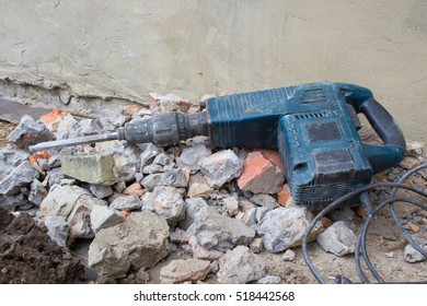 lying HammerDrill in the construction tool on a pile of bricks and stones