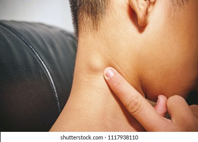 Lymph Node Swollen,  Closeup view of a young man with Sore throat or pain on the neck or thyroid gland he has inflammation lymph nodes in the neck, People body problem concept.