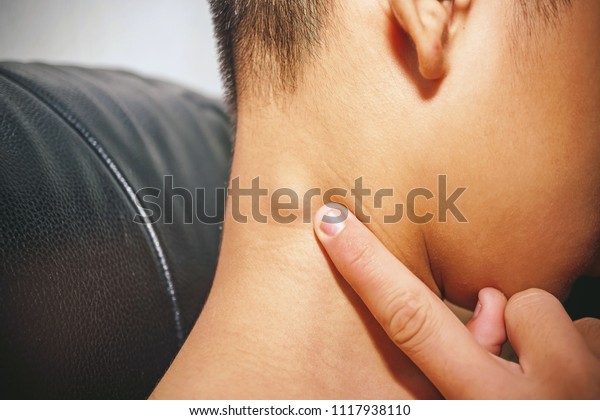 Lymph Node Swollen, \
Closeup view of a young man with Sore throat or pain on the neck or\
thyroid gland he has inflammation lymph nodes in the neck, People\
body problem concept.