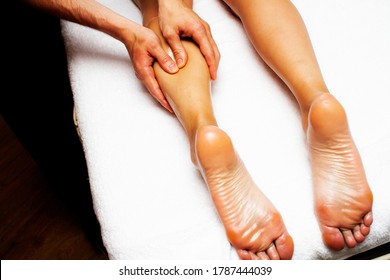 Lymphatische Dränage Massage der Beine und unteren Beine. Weibliche Füße in den Händen eines Masseurs.