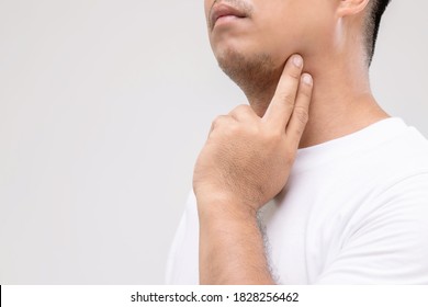 Lymphoma in men concept : Portrait Asian man is touching on his neck at lymph node position. Studio shot isolated on grey background