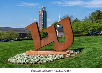 Lynchburg, Virginia - April 22, 2022: Large metal logo for Liberty University with the Freedom tower in the background . Freedom tower is part of the John W. Rawlings School of Divinity.