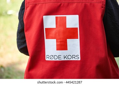 LYNGE, DENMARK - 23, JUNE 2016: The Back Of A Danish Red Cross Worker In A Red Vest Standing Outside On A Grrass Field