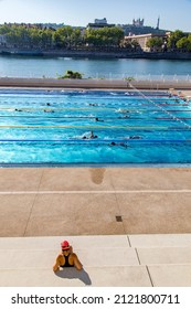 Lyon France August 2017: A Person Enjoying Summer Sun At Public Pool Complex Next To Rhone River 