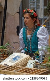 LYON, FRANCE, May 22, 2022 : A Young Woman Runs A Stand Of Plants And Herbsin Vieux-Lyon During The Fete De La Renaissance (Renaissance Festival).