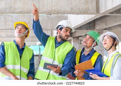 l.Young Middle Eastern engineer at construction site inspect construction with Asia team. Skilled professional work experience. Multi-ethnic civil engineering group unite cooperate same goal.