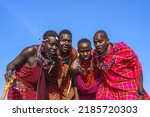 Maasai Mara man in traditional colorful clothing showing traditional Maasai jumping dance at Maasai Mara tribe village famous Safari travel destination near Maasai Mara National Reserve Kenya