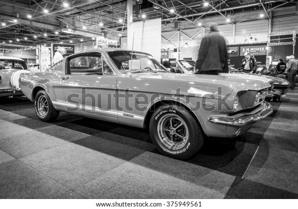 MAASTRICHT,\
NETHERLANDS - JANUARY 15, 2016: Pony car Ford Mustang GT (first\
generation), 1965. Black and white. International Exhibition\
InterClassics & Topmobiel\
2016