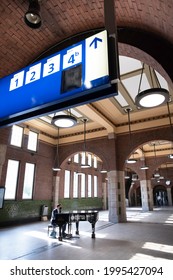 MAASTRICHT, NETHERLANDS - JUNE 19 2021: Man With A Face Mask Plays The Piano On A Grand Piano That Can Be Used By Everyone In The Hall Of The Historical Maastricht Central Station