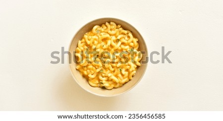 Mac and cheese in bowl over light background with free text space. Top view, flat lay