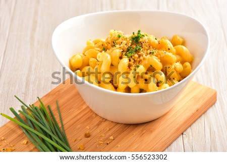 Mac and Cheese with Bread Crumbs, Chive Garnish, on Dark Wood Surface and Light Wood Surface. 