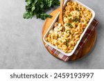 Mac and cheese with breadcrumbs oven baked, top view, copy space. Traditional american meal, macaroni pasta and cheese sauce casserole.