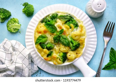 Mac And Cheese With Broccoli In A Baking Dish Over Light Blue Slate, Stone Or Concrete Background.Top View.