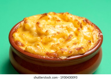 Mac And Cheese In A Ceramic Bowl On A Green Background. Macaroni And Cheese Oven Baked With Bechamel Sauce.