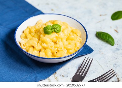 Mac And Cheese On Rustic White Board With Basil Leaves