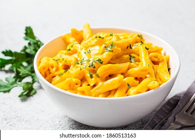 Mac and cheese in white bowl, gray background. Cheese pasta in a bowl.