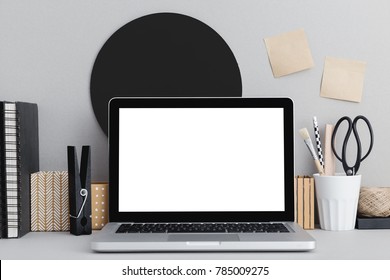 Mac, Laptop in stylish workspace. Sticky notes, stationery, books. Grey color mock up.