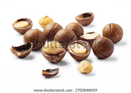 Macadamia nuts with broken nut and nutshell isolated on white background, closeup