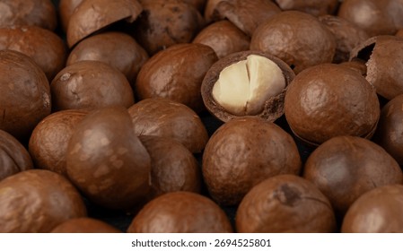 Macadamia nuts close up pattern. Natural raw peeled macadamia seeds and shells background, the hardest and most expensive nuts in the world bg