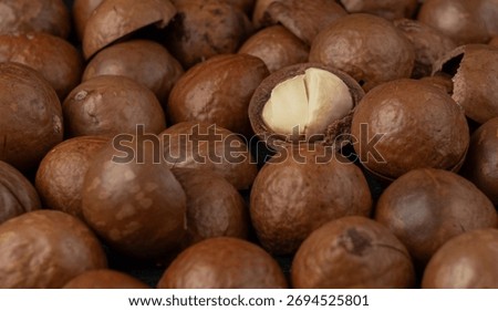 Macadamia nuts close up pattern. Natural raw peeled macadamia seeds and shells background, the hardest and most expensive nuts in the world bg