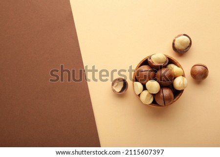 Macadamia nuts on brown and beige background.