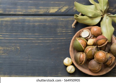 Macadamia nuts in shell on wooden table
