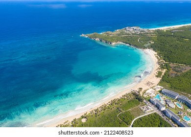 Macao beach with sandy coastline, turquoise water and stone cliff. Famous shore for surfing in Dominican Republic. Aerial drone view 