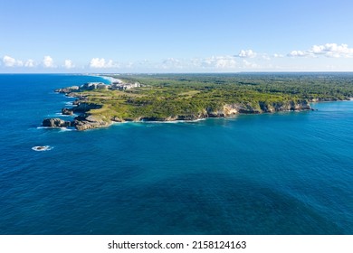 Macao beach with sandy coastline, turquoise water and stone cliff. Famous seashore for surfing in Dominican Republic. Aerial panorama view 