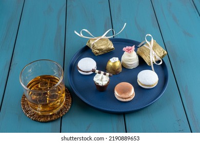 Macaron Next To Small Chocolate Glass With Whipped Cream, Walnut Cameo, Truffle And Whiskey Glass.