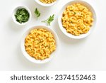 Macaroni and cheese in bowl over white background. Top view, flat lay
