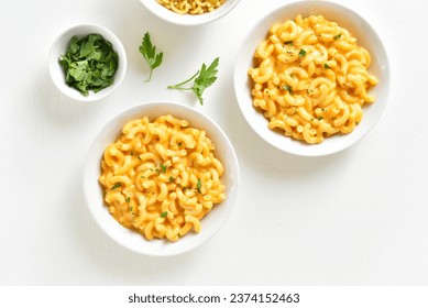 Macaroni and cheese in bowl over white background. Top view, flat lay