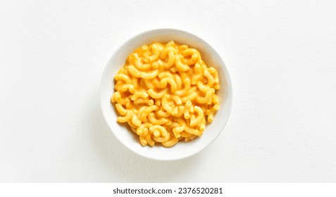 Macaroni and cheese in bowl over white background with copy space. Top view, flat lay